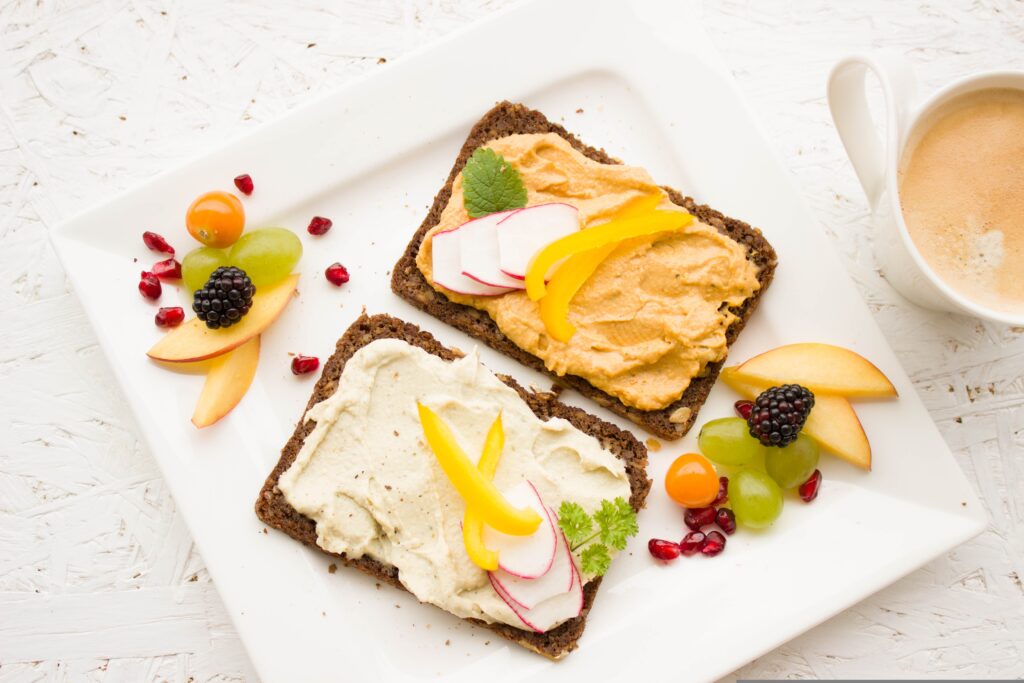 Illustration représentant 2 tartines de houmous avec quelques fruits, exemple de petit-déjeuner équilibré en naturopathie